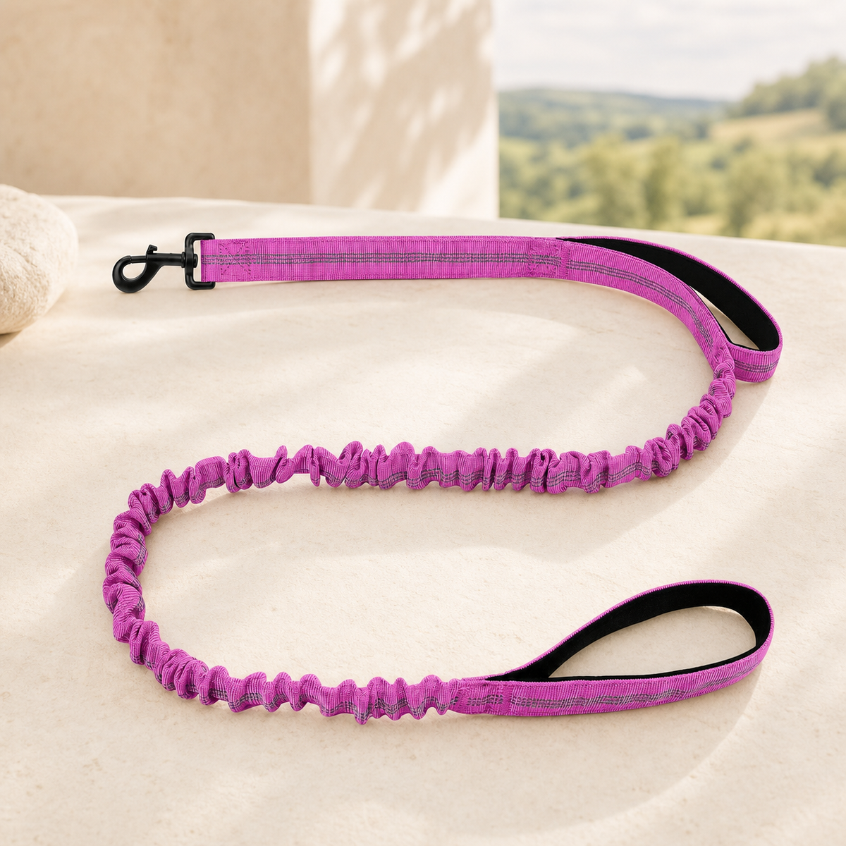 Shock-absorbing bungee dog lead in burgundy on a warm stone setting