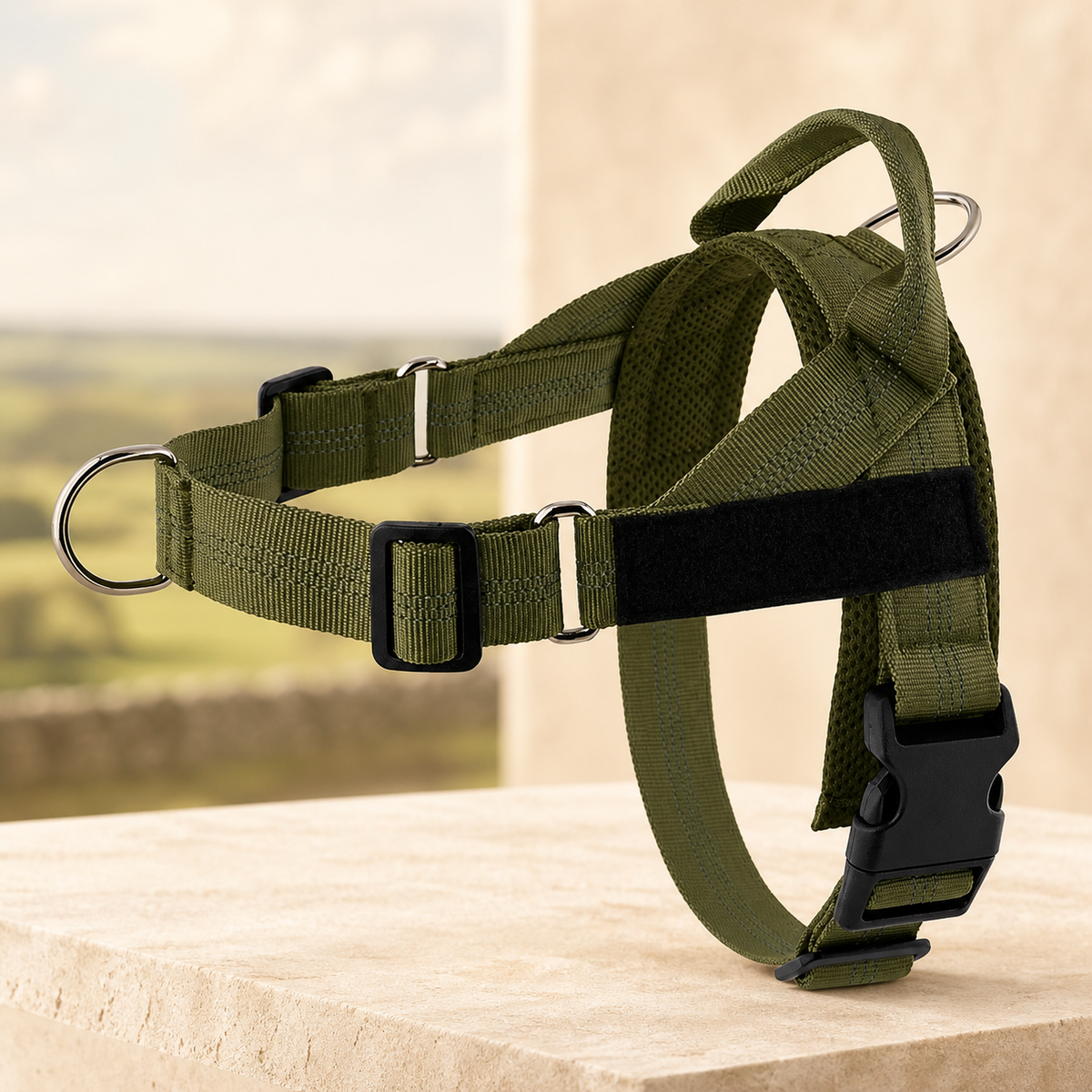 Adjustable reflective dog harness in army green on a warm stone setting
