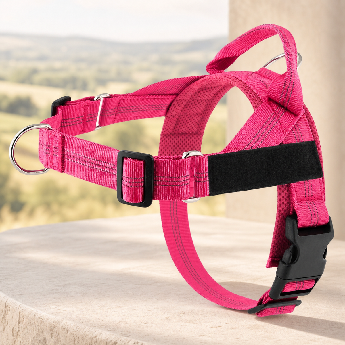 Adjustable reflective dog harness in pink on a warm stone setting
